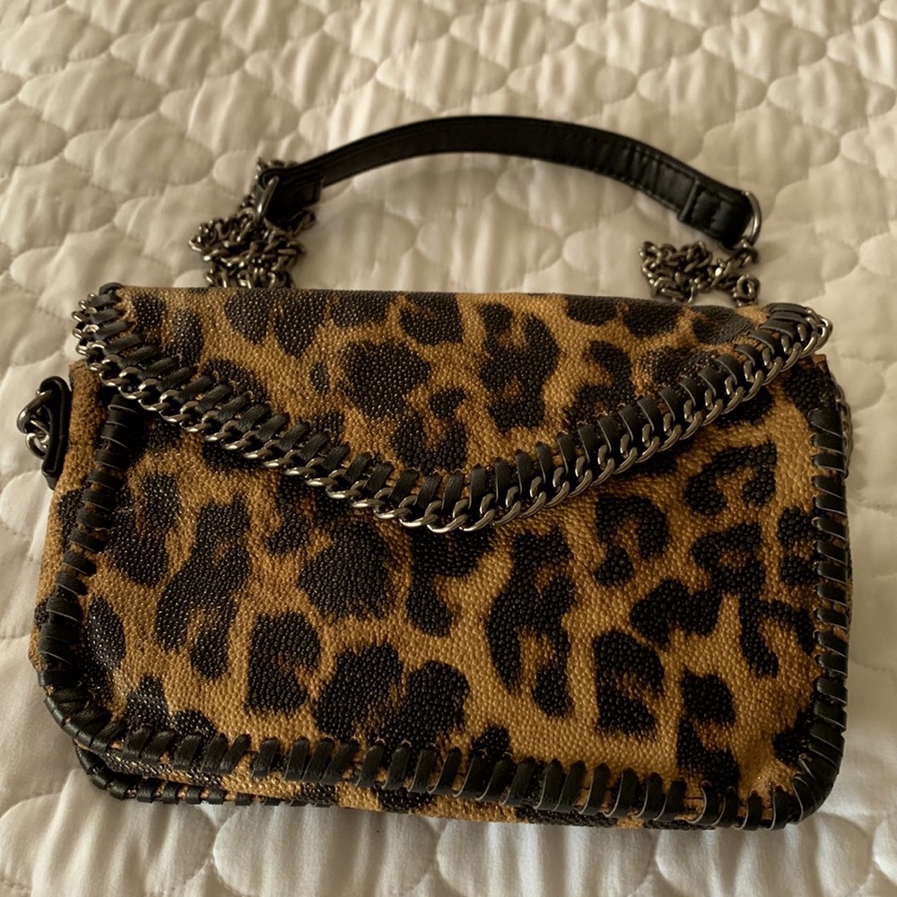 NWOT Fun Leopard pattern leather like purse trimmed in metal and black.